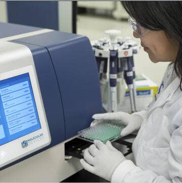 Wissenschaftler, der am Mikroplatten-Reader arbeitet